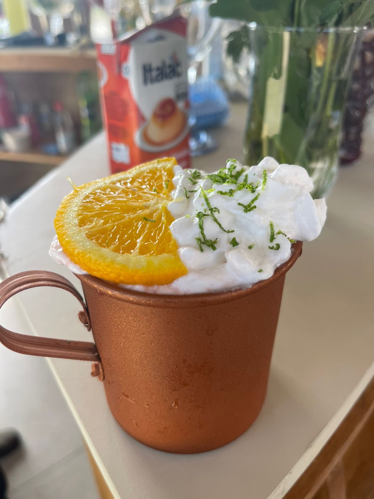 Drink especial em caneca de cobre com chantilly e laranja